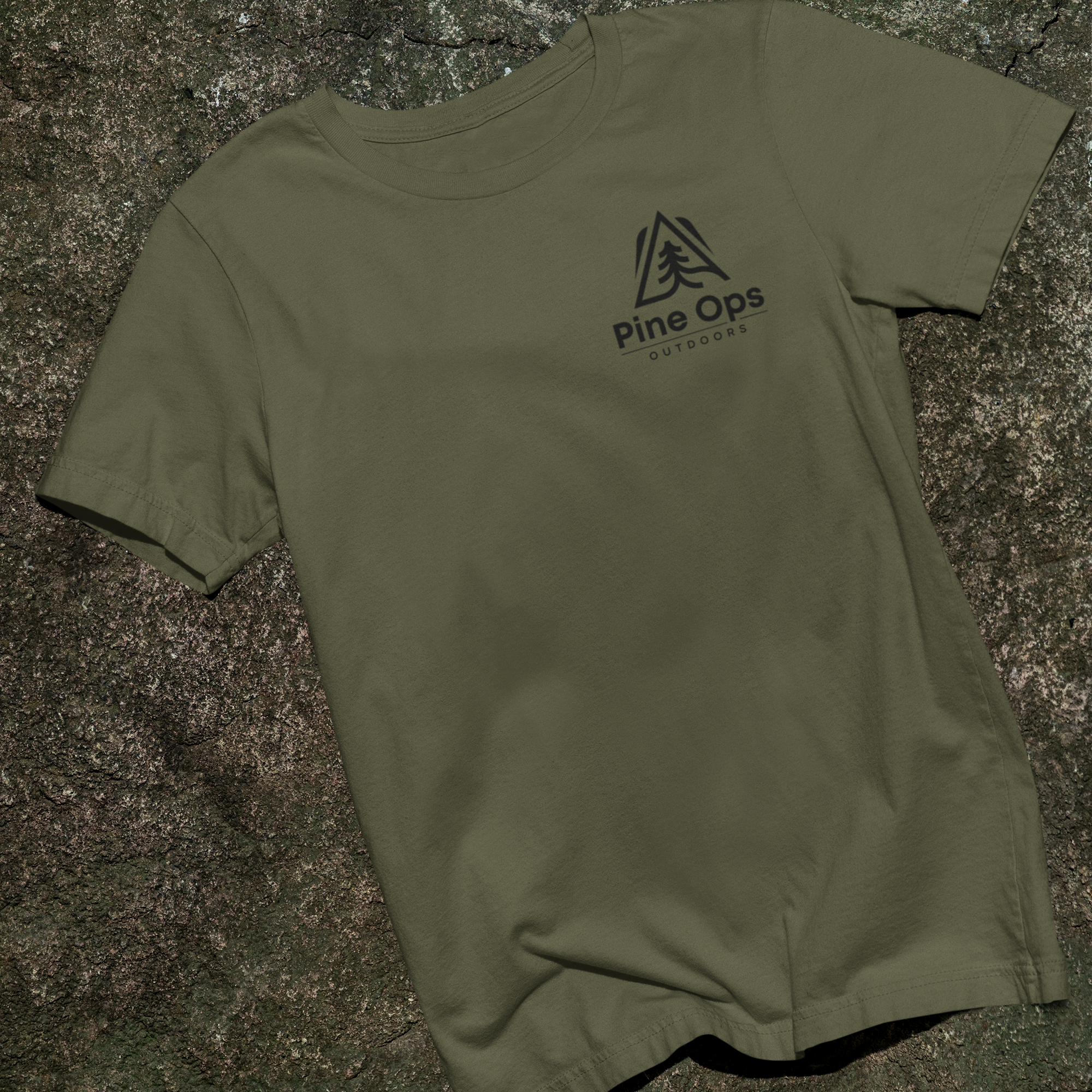 Green t-shirt with pine op outddors logo on a stone surface